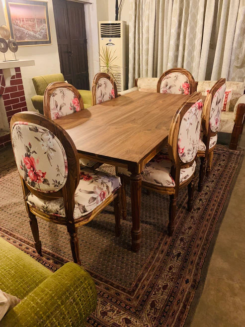 Handcrafted dining room furniture with wooden chairs and a large modern table in a bright, stylish room