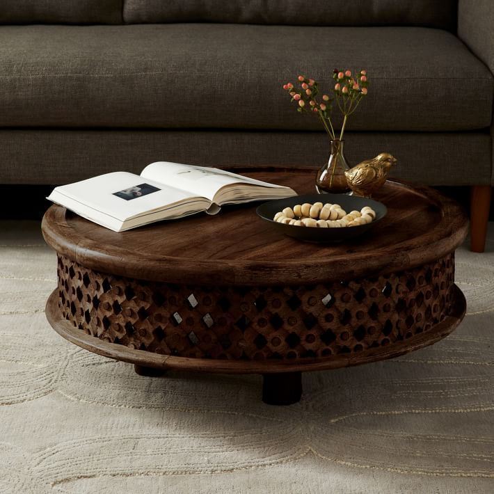 This coffee table is a center table made of solid mango wood and hand carved. And it has round top with brim surface.