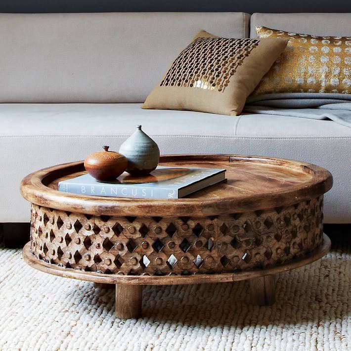 This coffee table is a center table made of solid mango wood and hand carved. And it has round top with brim surface.