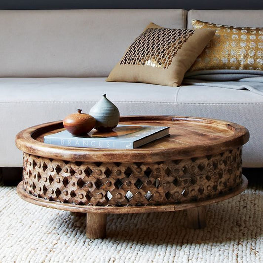 This coffee table is a center table made of solid mango wood and hand carved. And it has round top with brim surface.